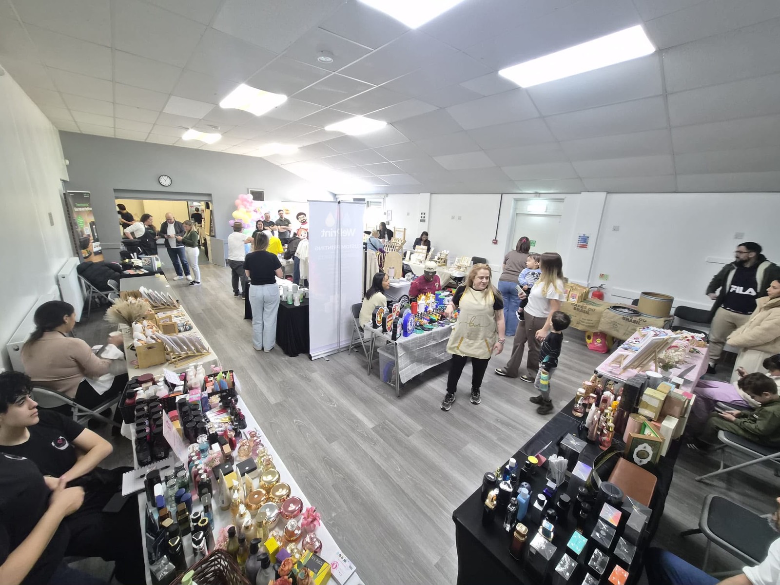 Busy market hall with stalls and visitors at the first edition