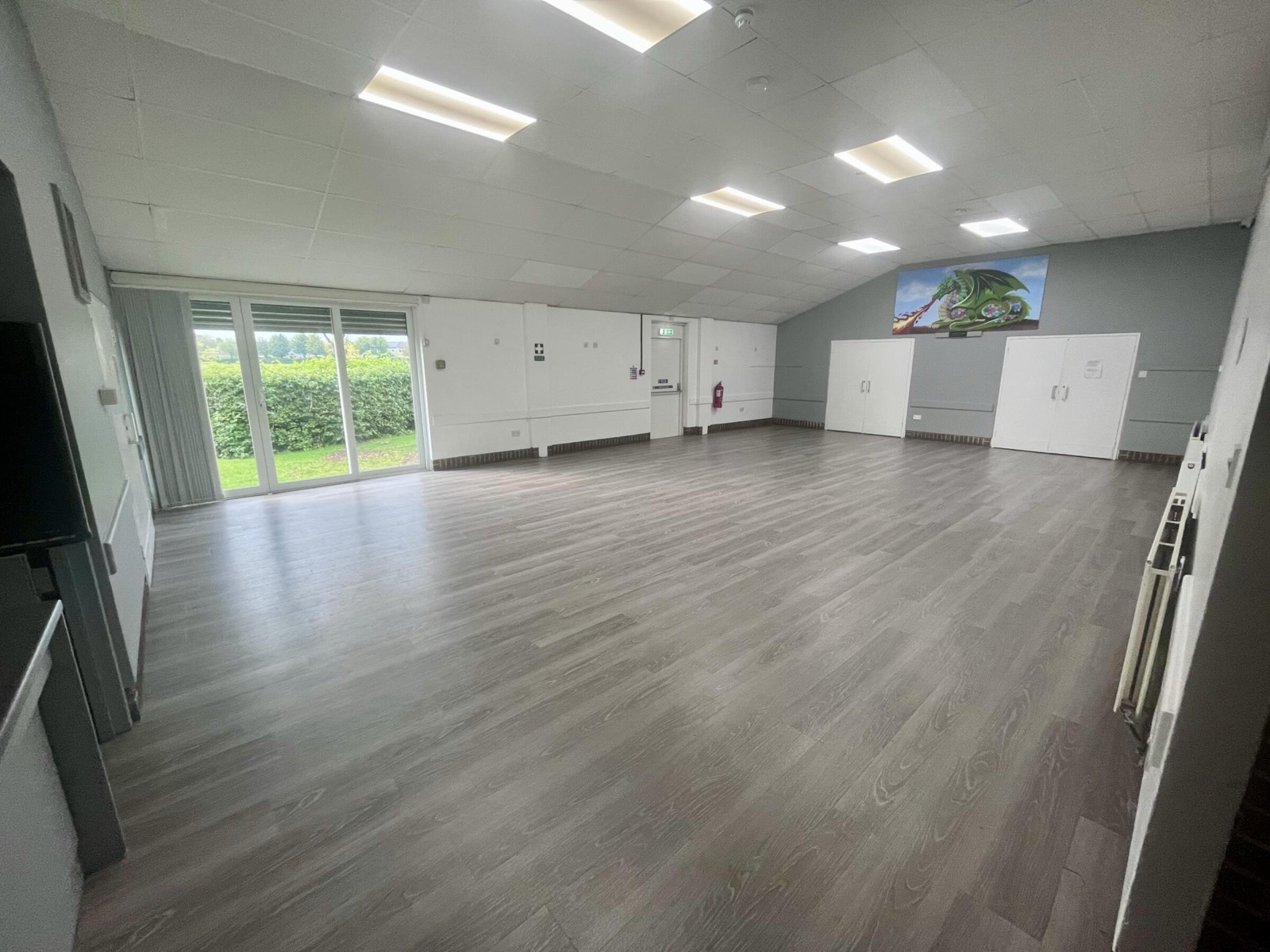 Inside the bright main hall at Meadowcroft Community Centre, with wooden flooring and garden doors